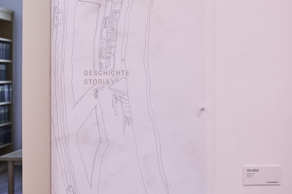 Paul Thuile benutzt die alten, von Geschichten durchdrungenen Mauern der heutigen Bibliothek als Zeichengrund. Dicht am Türstock positioniert er in seiner unverkennbaren Linienführung, wie eine Vorschau auf die Realität, einen Einblick in den dahinterliegenden Raum. Auf der Suche nach dem unauffälligen Normalem erkundet Paul Thuile sorgfältig die Umgebung, bevor er mit der Arbeit vor Ort beginnt. Seine Zeichnungen sind unsere Lupe zum Scharfsehen übersehener Details und unser Röntgenblick für eine achtsame Wahrnehmung des Lebensraums.